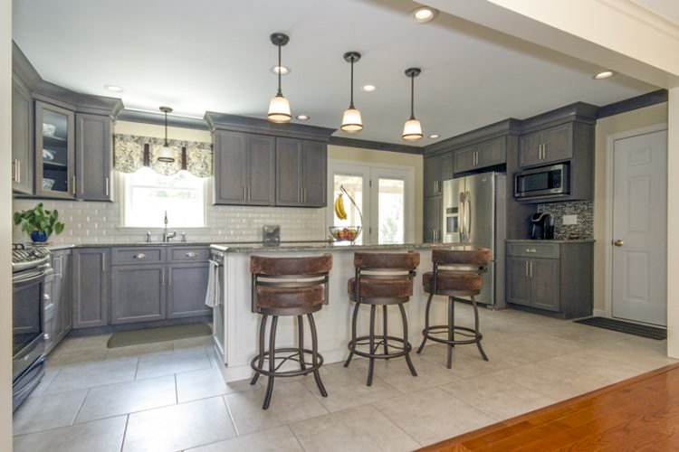 An open concept kitchen with an island and bar height stools. 