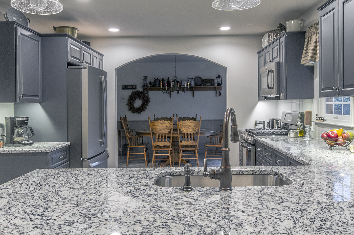 A kitchen with an open archway leading to the dining room.