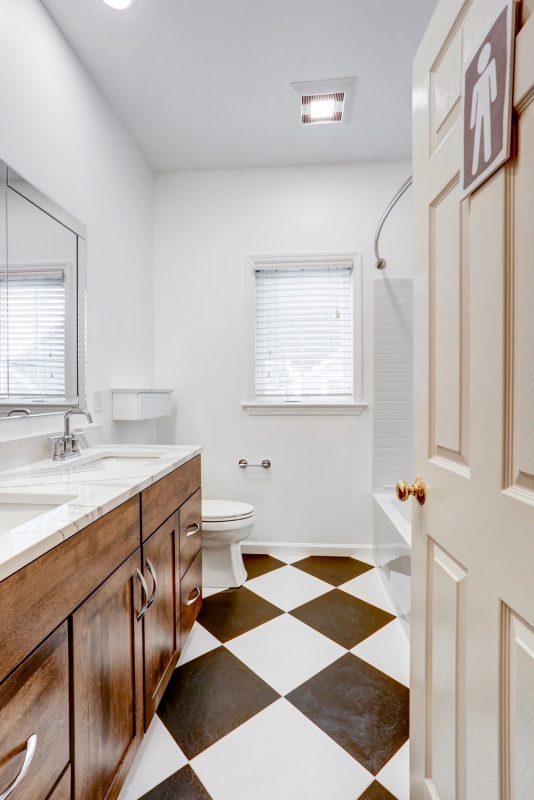 bathroom with checkered floors and wood cabinets