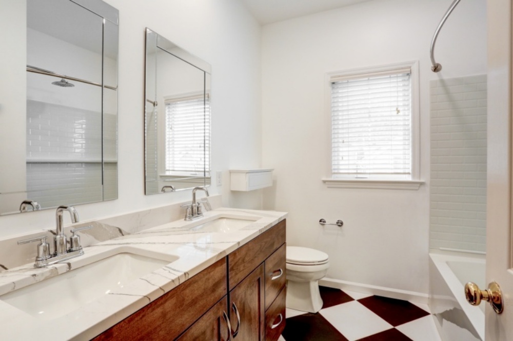 bathroom with remodeled sink, toilet, and shower