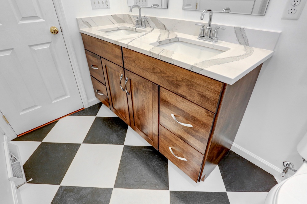 jack and jill bathroom sink with wood cabinets and checkered flooring