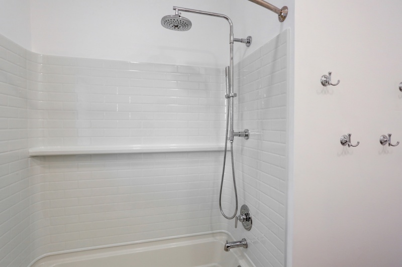 newly remodeled shower with white tile