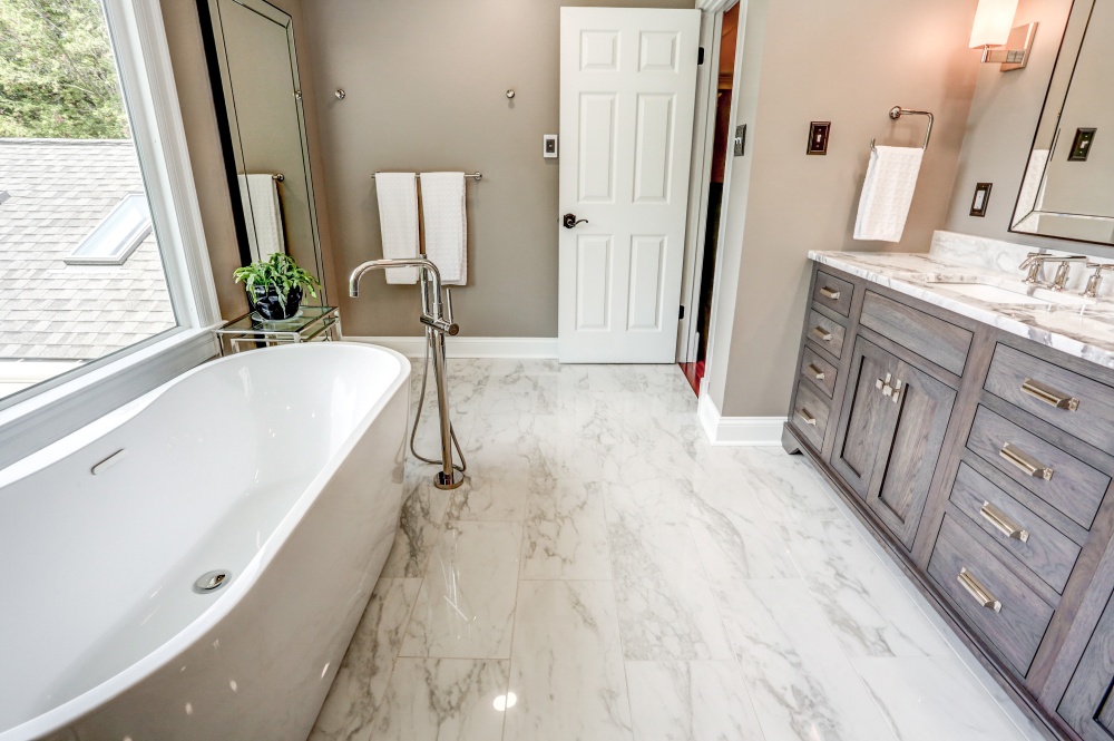 bathroom with large soaking tub and tile flooring