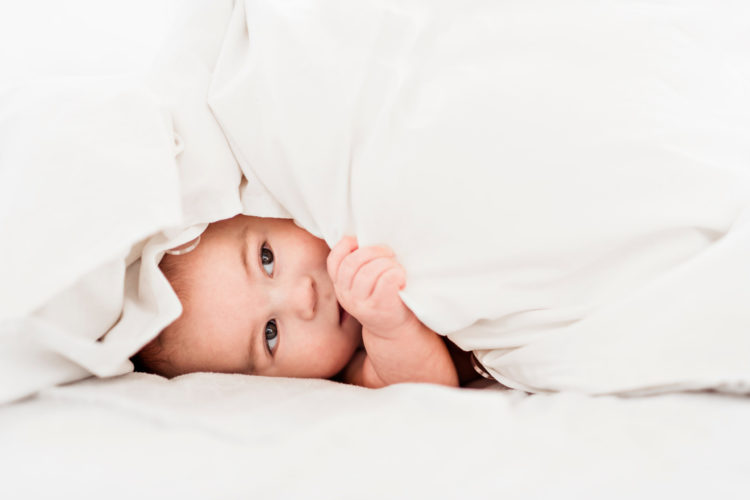 A Portrait of a baby boy on the bed in bedroom